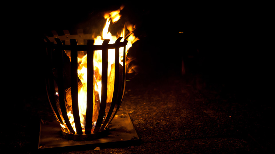 Ein Feuerkorb, in welchem Holz brennt. 