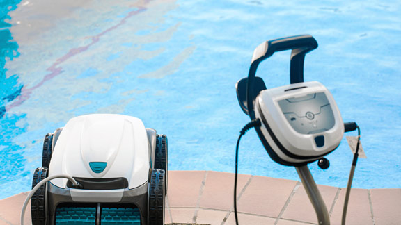 Man sieht einen Poolroboter und einen Pool im Hintergrund.